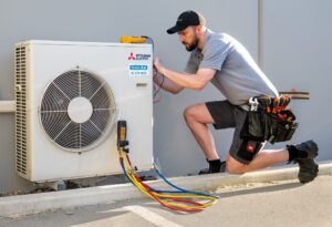 Beattie Air employee providing maintenance on Mitsubishi HVAC heat pump in Christchurch